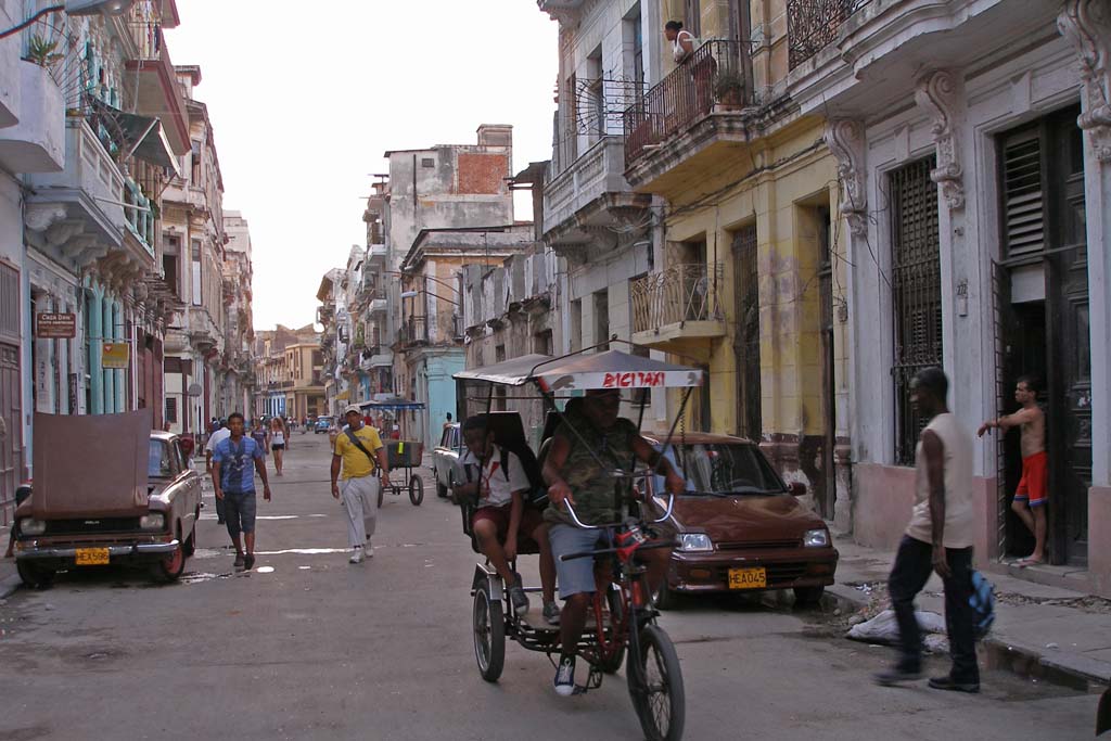 A typical street, complete with bicitaxi and a Lada with its bonnet up.